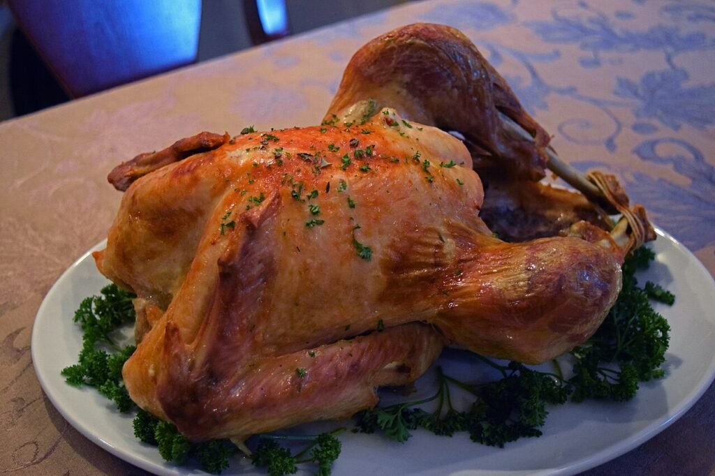 A roasted turkey on a serving platter garnished with parsley